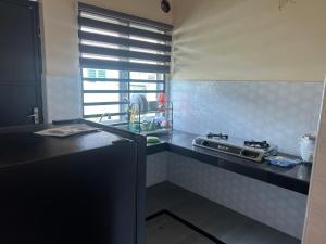 a kitchen with a stove and a counter top at Singgah homestay in Gua Sai +3 photos