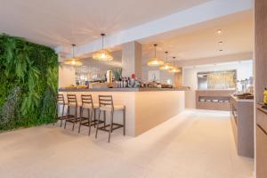 a kitchen with a bar with stools at Marins Naiya Boutique Hotel in Cala Bona