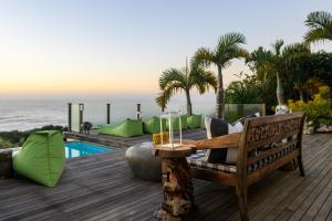 a wooden deck with a bench next to a pool at Nakai Beach Homestay in Trafalgar