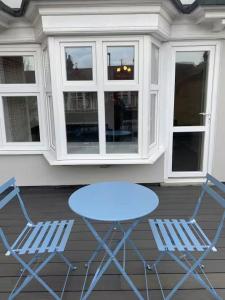 two chairs and a blue table on a porch at Dream Yard Apartments in Southend-on-Sea