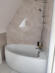 a white bath tub in a bathroom with a shower at Proche parc 3 curés in Coatéval +2 photos
