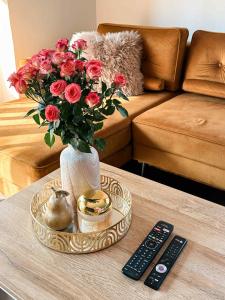 a vase of roses on a table next to a remote control at Pajulille Holiday Home Pärnu in Eametsa