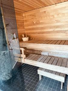 a wooden sauna with two benches and a shower at Pajulille Holiday Home Pärnu in Eametsa