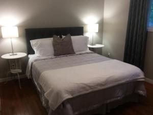 ein Schlafzimmer mit einem großen Bett mit zwei Lampen in der Unterkunft Westwood Cottage License #045-2020 in Niagara on the Lake
