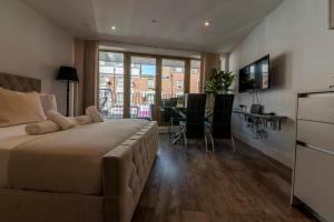 a bedroom with a large bed and a dining room at Luxe London Retreat in London