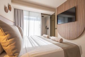 a bedroom with a large white bed with a large mirror at Marins Naiya Boutique Hotel in Cala Bona