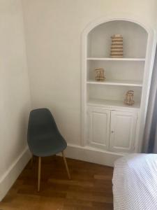 a room with a chair and a white shelf at Appartement T2 - Centre-ville in Saint-Pourçain-sur-Sioule