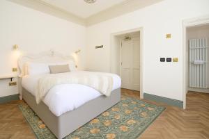 a white bedroom with a large bed and a rug at The Stella Historic Llandudno Bed & Breakfast in Llandudno +35 photos