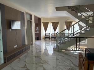 a lobby with a glass staircase and a living room at Symphony in Ooty +16 photos