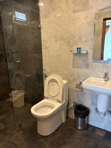 a bathroom with a toilet and a sink at Symphony in Ooty