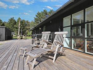 two wooden chairs sitting on a wooden deck at 8 person holiday home in Hals-By Traum in Hals