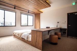 a bedroom with a bed and a desk and windows at vacation house KAGO in Fujiyoshida