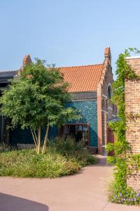 a brick building with a tree in front of it at Jonojé Luxury Suites in Bruges