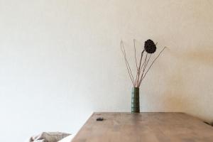 a vase with sticks in it sitting on a table at vacation house KAGO in Fujiyoshida