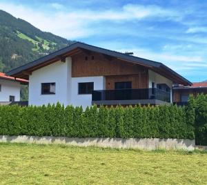 a white house with a black roof at Apart Garber in Zellbergeben