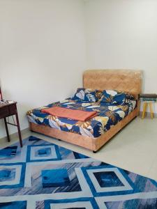 a bedroom with a bed and a rug on the floor at Ryhan-Cha Homestay near Afamosa Waterpark in Gua Sai