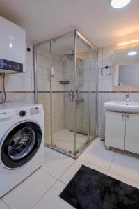 eine Waschmaschine in einem Badezimmer mit Dusche in der Unterkunft Maxihomes Near Hadrian Gate & Beach, with Sea Views in Antalya