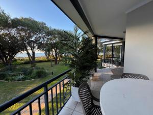 a balcony with a table and chairs and the ocean at 5@CapeView, beachfront Geographe Bay in Busselton
