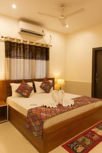 a bedroom with a large bed with white sheets at Shri Radha Kunj Vrindavan in Vrindāvan +23 photos