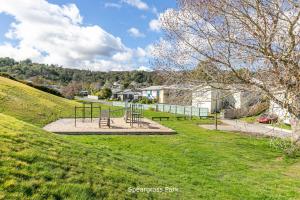 a park with benches on a grassy hill at Modern 1 Bed Smart Flat in Upper Hutt with Full Kitchen, Parking - 5 minutes to Brewtown in Upper Hutt