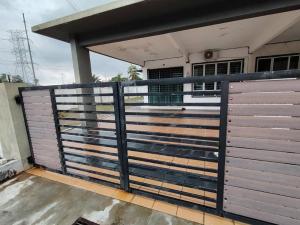 a metal fence with a gate in front of a house at Singgah homestay in Gua Sai