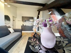 un jarrón blanco con flores sobre una mesa en la sala de estar en POLKE - appartement 3 personnes - check in h24 - wifi, en Lyon