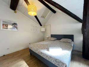 Un dormitorio con una cama y una lámpara. en POLKE - appartement 3 personnes - check in h24 - wifi, en Lyon 7 fotos más