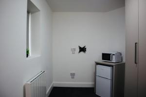 a kitchen with a microwave on top of a refrigerator at Harrow Hotel in Harrow