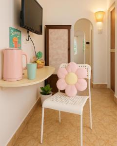 a room with a table and a chair with a flower on it at Florin Stays in Chapora