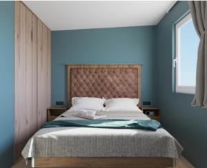 a bedroom with a bed with blue walls and a window at Camping Nord in Klopein am Klopeiner See