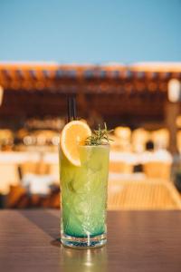 a drink with an orange slice sitting on a table at Saint Nicolas Hotel in Himare