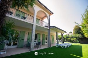 une maison avec une terrasse et une pelouse dans l'établissement La Casa del Lago, à Manerba del Garda