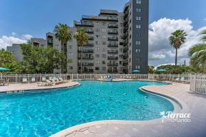 a swimming pool in front of a tall building at Volcano View 2 Bed 2 Bath Condo with Balcony in Orlando
