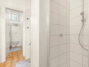 a white bathroom with a shower and a toilet at Stilvolle Gartenwohnung im Villenviertel Villachs in Villach +24 photos
