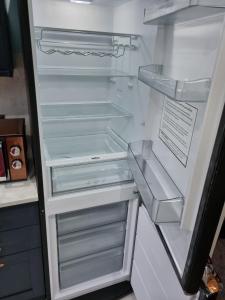 an empty refrigerator with its door open in a kitchen at No3 Spacious Apartment Cockermouth in Cockermouth