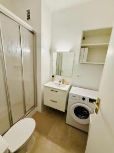a white bathroom with a sink and a washing machine at Beach and Sun two minutes away in Nice