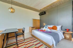 a bedroom with a bed and a table and a desk at Tegeh Townhouse Complex Modern 1BR In Uluwatu in Ungasan +24 photos