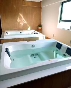 a large bath tub in a bathroom at VAN GOGH-SE Studio privado com Rooftop, garagem, piscina aquecida in Salvador
