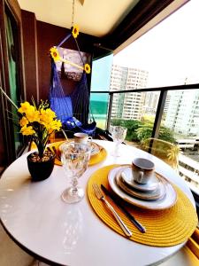 a white table with yellow napkins and plates on it at VAN GOGH-SE Studio privado com Rooftop, garagem, piscina aquecida in Salvador +43 photos