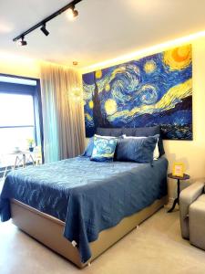a bedroom with a blue bed with a painting on the wall at VAN GOGH-SE Studio privado com Rooftop, garagem, piscina aquecida in Salvador