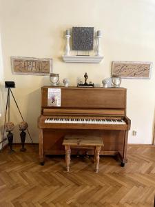 a piano in a room with a wooden floor at Casa Crown in Sighişoara
