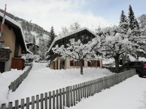 a house with a fence and trees covered in snow at Glacier Views & Ski Trails in Blatten bei Naters +32 photos