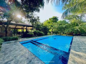a swimming pool in the middle of a yard with trees at Ele Camp Udawalawe in Udawalawe