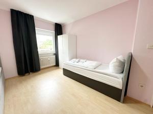 a small bedroom with a bed and a window at SUNNYHOME Monteurwohnungen und Apartments in Weiden in Weiden +2 photos
