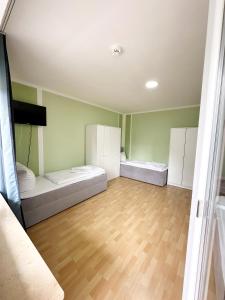 a room with two beds and a wooden floor at SUNNYHOME Monteurwohnungen und Apartments in Weiden in Weiden