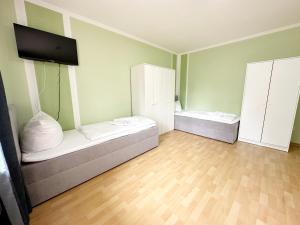 a room with two beds and a flat screen tv at SUNNYHOME Monteurwohnungen und Apartments in Weiden in Weiden
