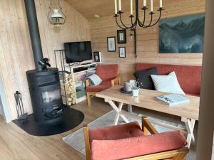a living room with a wood stove and a table at Cosy cabin in Hemsedal with ski in-ski out to Solheisen in Hemsedal