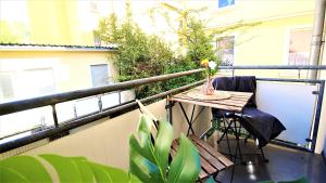 a table with a vase of flowers on a balcony at homie stay Schiestlstraße - Moderne Altbauapartments, Nahe Stadtzentrum & Weinberge in Würzburg