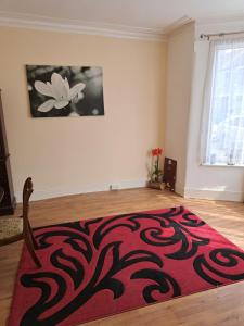 a living room with a red rug on the floor at London Ilford town house in Ilford