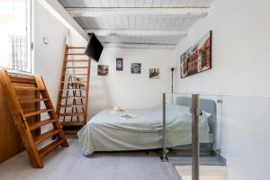 Habitación pequeña con cama y escalera en Casa Nica Nica, en Palermo